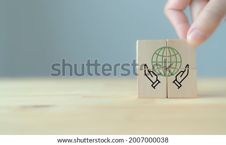 Social responsibility core value concept with hand and globe icon on cubes. CSR , eco green sustainable living, zero waste, plastic free, earth day, world environment day, responsible consumption.