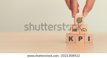 KPI, Key Performance Indicator. Businessman holds cube with KPI icon; business goals, performance results and indicators . For business planning and measure success, target achievement. Copy space. Imagine de stoc © 
