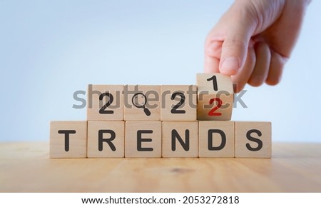 2022 trend concept. Hand flip wooden cube change year 2021 to 2022. Beautiful white background, copy space. Used for banner in trend concept in new year for monitoring new business opportunities. Foto d'archivio © 