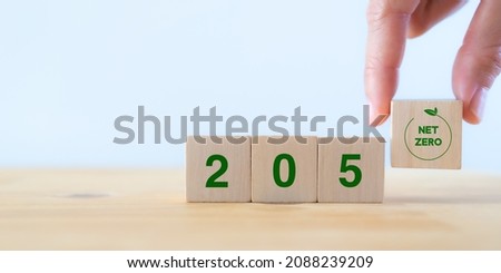 Net zero by 2050. Carbon neutral. Net zero greenhouse gas emissions target. Climate neutral long term strategy. No toxic gases. Hand puts wooden cubes with net zero icon in 2050 on white background. 商業照片 © 