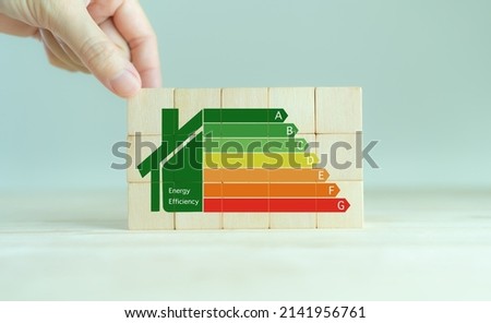 Energy efficiency and home improvement concept. Ecological and bio energetic house. Energy class;house efficiency rating. Low energy to save money. Hand holds wooden cubes with energy efficiency scale ストックフォト © 