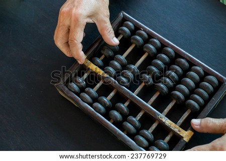 Old asian woman hands accounting with the old abacus