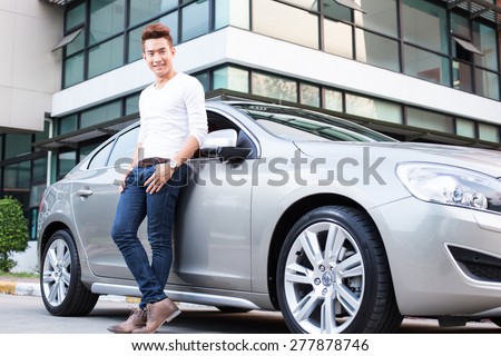 Portrait of an handsome smiling asian business man with his car and white shirt