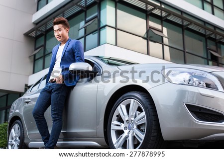 Portrait of an handsome smiling asian business man with his car and white shirt and blue coat