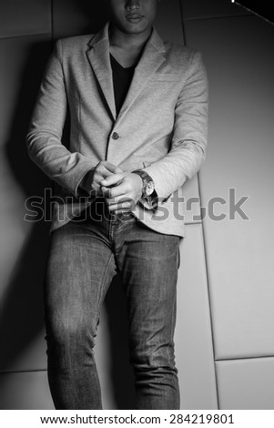 Black and White  Young fashion man\'s legs in blue jeans and brown boots on wooden floor