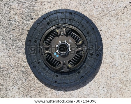 Old clutch disc on a cement background