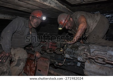 Donetsk, Ukraine - August, 16, 2013: Miners near the coal mining shearer. Mine is named Chelyuskintsev