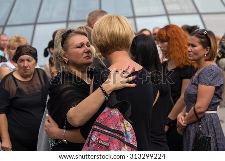 Kiev, Ukraine - September 04, 2015: Women in mourning garb express support for each other at the funeral of the deceased in the war volunteer