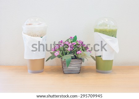 Artificial flowers in a vase ice tea and ice coffee on the table