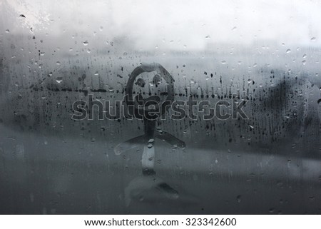 The human figure on the misted window