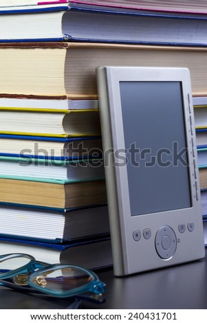 E-book and glasses on a background paper books