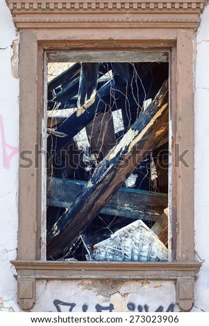 Window of a ruined house. Inside the visible beams and floors
