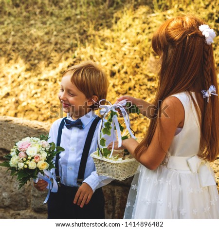 Foto Bild Ringträger bei Gartenhochzeit spielt mit Blumenstrauß