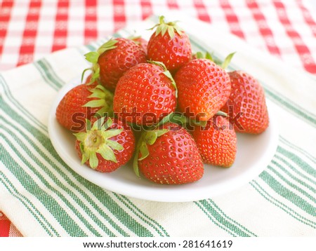 Strawberries on a white plate and white and green table napkin