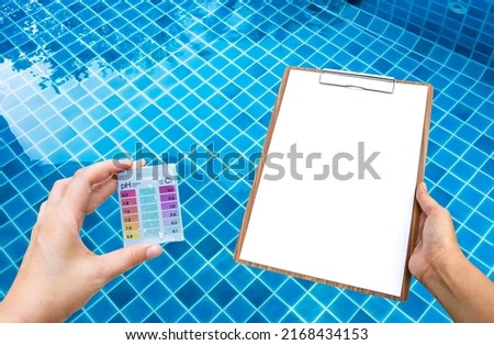 Female hand holding water tester and blank paper on wooden clipboard over clear swimming pool water background, pool water treatment checklist Photo stock © 