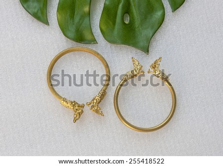 Thai gold bracelet dragon design with green leaf background