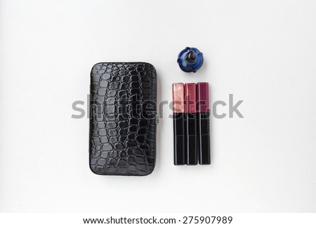 Black leather bag, blue perfume bottle, blue perfume bottle and 3 colors lips gloss on white background