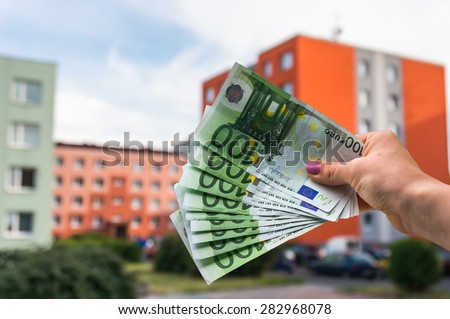 Property buyer holding euro banknotes and buying beautiful flat from real estate agencies on blurred background