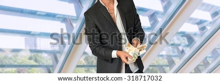 Disheveled man in business suit with money in office