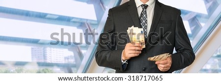 Man in business suit with money in office
