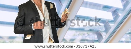 Disheveled businessman in a black suit and money in pockets in office