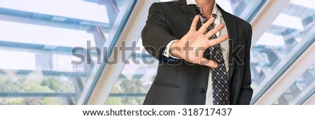 Man in suit gestures leave me alone in office