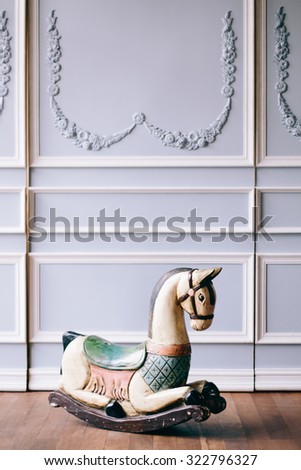Antique reproduction wood toy rocking horse on vintage background and wooden floor - Vintage grunge empty interior, Selective Focus