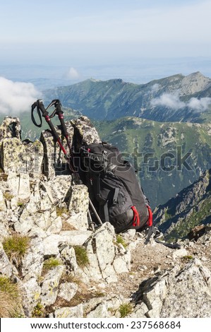 Backpack and trekking poles range of tourist on a background of mountains