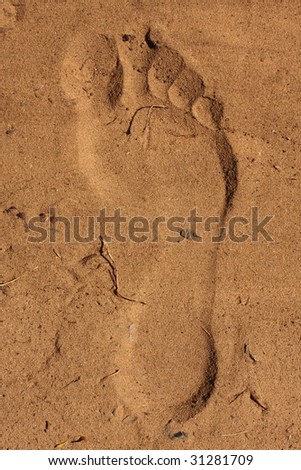 Foot imprint in sand which looks inverted due to lighting