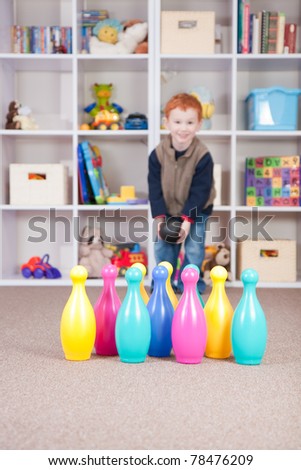 Boy playing ten pin bowling in play room