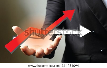 Hand holding a rising red arrow, representing business growth. vintage tone