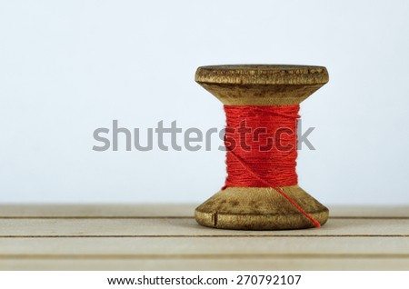 Old spool of thread closeup. Tailor\'s work table. textile or fine cloth making.