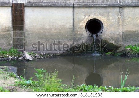 Water pollution in river. Dirty water stems from the pipe polluting the river. Industry not treat water before drain.