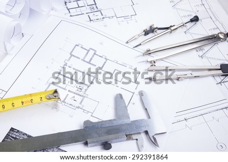 Architectural project, blueprints, blueprint rolls and divider compass, calipers, folding ruler  on plans Engineering tools view from the top. Copy space. Construction background.