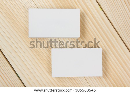 Blank white business cards on wood background