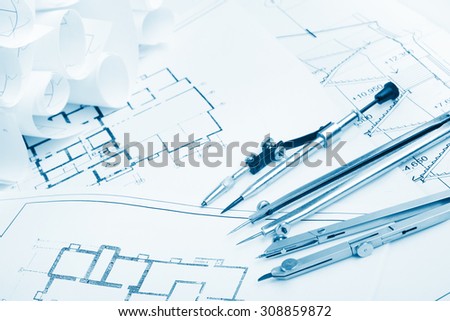 Architectural project, blueprints, blueprint rolls on plans. Engineering tools view from the top. Copy space. Construction background. Blue toned