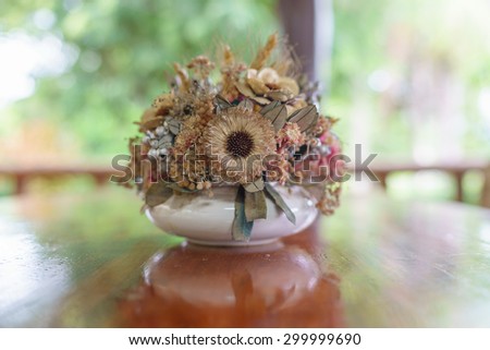 Decorated   vase  with dried flowers of all kinds  on  dinner  table.