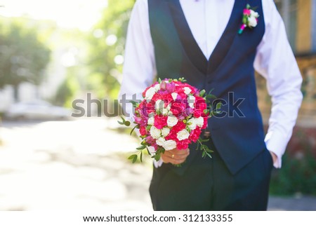 Man with wedding bouquet at the summer day