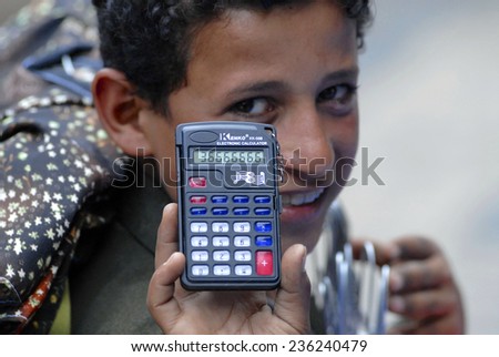 SANA\'A, YEMEN - SEPTEMBER 18, 2006: Unidentified young market seller demonstrates calculator to bargain the price on September 19, 2006 in Sana\'a, Yemen.