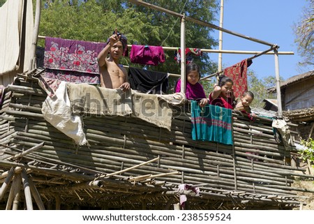 BANDARBAN, BANGLADESH - FEBRUARY 20, 2014: Unidentified people stand at the veranda of the Marma hill tribe traditional house on February 20, 2014 in Bandarban, Bangladesh.