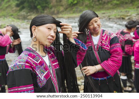 LONGJI, CHINA - MAY 06, 2009: Unidentified women brush and style hair on May 06, 2009 in Longji, China. Red Yao women living in Longji Yao village have one of the longest hair in the world.