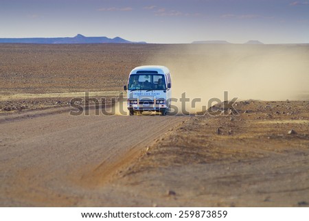 COOBER PEDY, AUSTRALIA - NOVEMBER 11, 2007: Unidentified people ride tourist bus by the Breakaways Reserve on November 11, 2007 circa Coober Pedy, Australia.