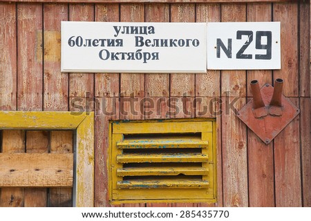 PYRAMIDEN, NORWAY - SEPTEMBER 03, 2011: Exterior of the street sign in cyrillic at the house wall at the abandoned Russian arctic settlement Pyramiden, Norway.