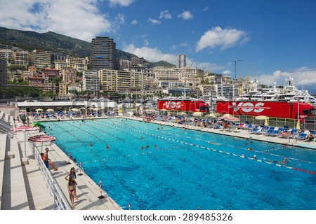 MONACO, MONACO - JUNE 17, 2015: Unidentified people swim and sunbathe at the open air public swimming pool in Monaco.