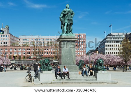 STOCKHOLM, SWEDEN - APRIL 28, 2011: Unidentified people enjoy lunchtime sitting under KARL XII statue at Kungstradgarden in Stockholm, Sweden.