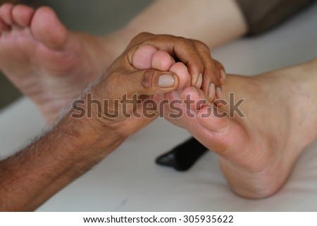 close up foot massage by old man\'s hands