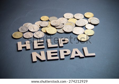 Help nepal with money is the concept here on blackboard. Wooden letters are here with different countries currencies.