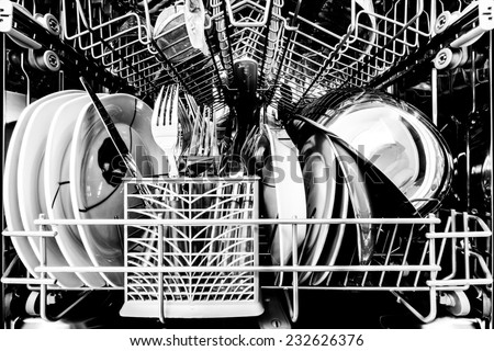 Dish washer full of clean dishes black and white