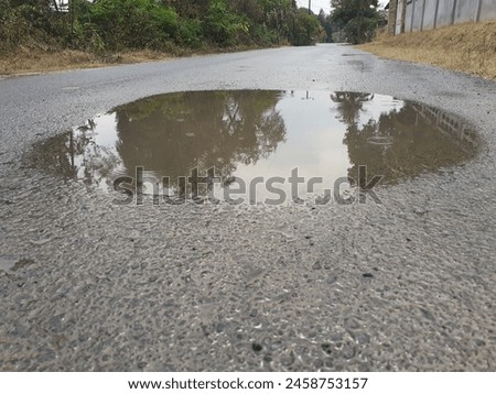 Similar – Foto Bild Pfützen auf einer Landstraße nach Regenfällen. Schwarz und weiß düstere Landschaft Szene