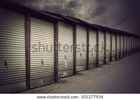 Row of metal garage doors in run down residential area
